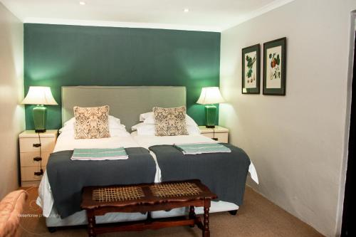 a bedroom with a bed with a green wall at Newstead Farm - Country Cottages in Curryʼs Post