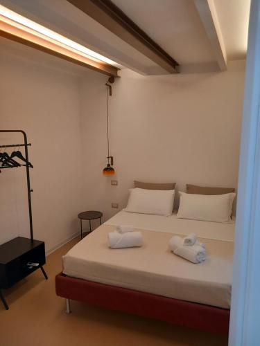 a bedroom with a bed with two towels on it at La casetta Guest House Oristano in Oristano