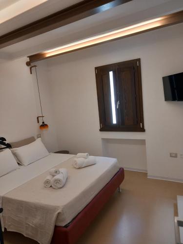a bedroom with two beds with towels on top at La casetta Guest House Oristano in Oristano
