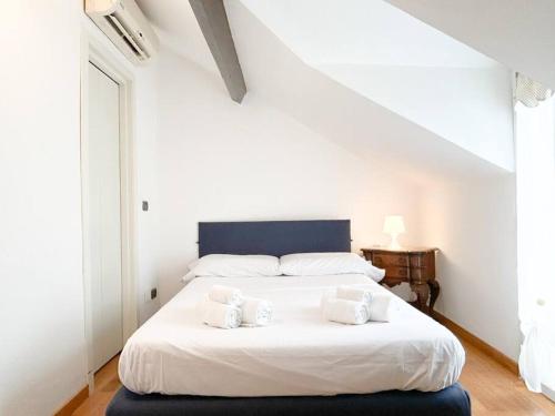 a bedroom with a white bed with two pillows on it at [Elegante mansarda] 300mt dal mare - Centro - WiFi in Savona