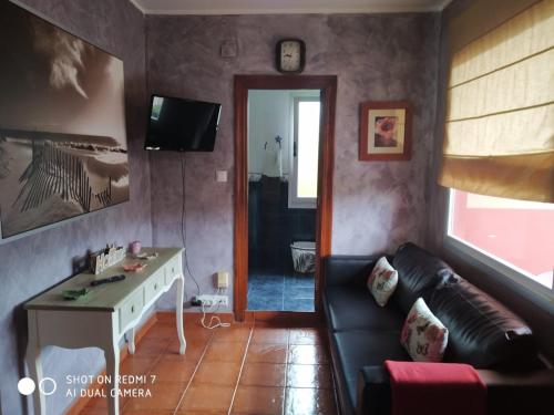 uma sala de estar com um sofá e uma mesa em La Buganvilla em Ribadesella