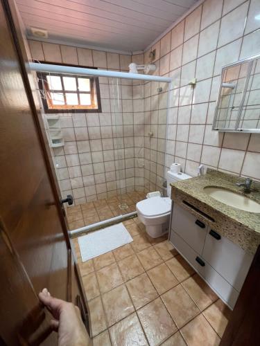 a small bathroom with a toilet and a sink at Flat Pé na Areia Cabo Frio in Cabo Frio