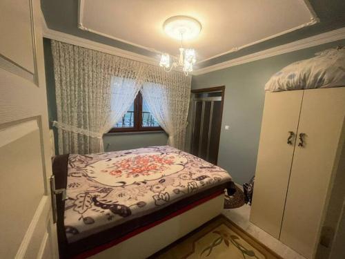 a small bedroom with a bed with a window at Aileye uygun müstakil ev in Arsin