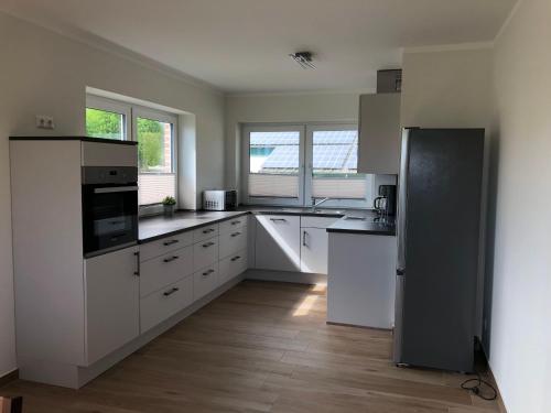 a large kitchen with white cabinets and appliances at Ferienhof-Micheel in Gammendorf