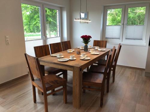 a wooden dining room table with chairs and flowers on it at Ferienhof-Micheel-Haeuser-bis-7-Personen in Gammendorf