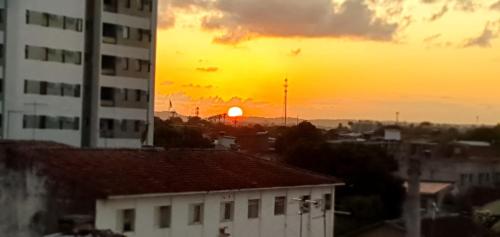 um pôr-do-sol sobre uma cidade com um edifício e edifícios em SUITE e QUARTOS -1 SUITE COM BANHEIRO PRIVATIVO - 2 QUARTOS DUPLOS COM BANHEIRO COMPARTILHADO em Recife