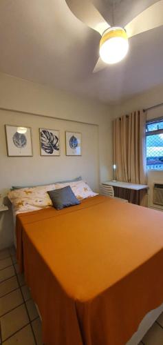 a bedroom with a large bed with an orange blanket at SUITE e QUARTOS-PERTO da UFPE- MAURICIO de NASSAU e Estacio de Sa - Recife in Recife