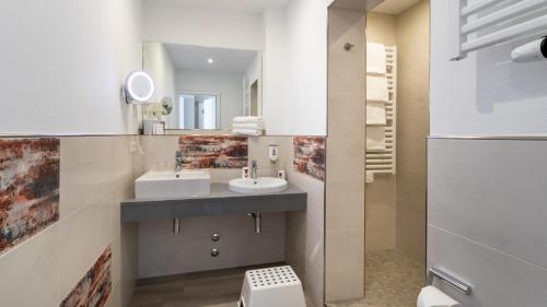 een badkamer met een wastafel en een spiegel bij Hotel Deichkrone - Familotel Nordsee in Norddeich