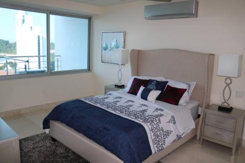 a bedroom with a bed and a large window at 09B Perfect 1-bedroom apartment with stunning view in ArraijÃ¡n