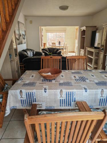 ein Wohnzimmer mit einem Tisch mit Stühlen und einem Sofa in der Unterkunft Hartenbos huisie in Hartenbos