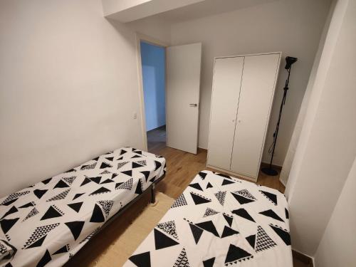 sypialnia z 2 łóżkami w kolorze czarno-białym w obiekcie Near Beach Cullera w mieście Cullera