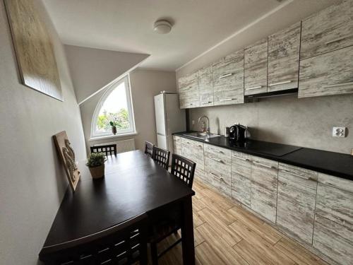 a kitchen with a table and chairs and a refrigerator at Apartamenty Firfas Rodzinny 11 in Bydgoszcz