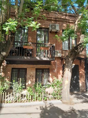 a brick building with a tree in front of it at Sunflower Hotel in Tbilisi City
