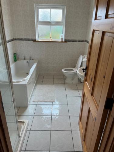 a bathroom with a tub and a toilet and a sink at Cúlú in Kincasslagh