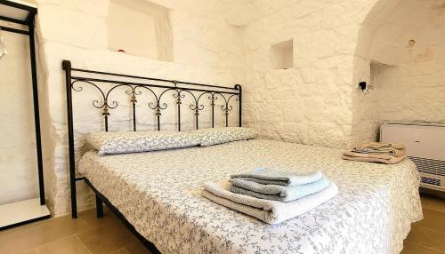 una camera da letto con un letto e asciugamani di Trulli Respiro dei Venti a Ostuni