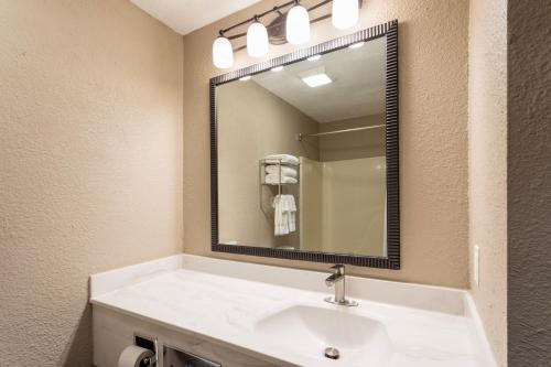 a bathroom with a sink and a large mirror at Grandstay Hotel & Suites in Waunakee