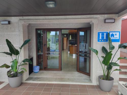 an entrance to a building with two potted plants at Hotel A Bota in Sanxenxo