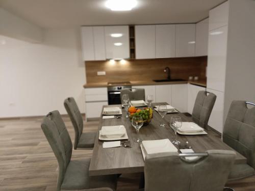 a dining room with a table and chairs in a kitchen at Apartmani Srdarović in Drage