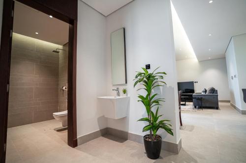 a bathroom with a toilet and a sink and a plant at Paradise of North Riyadh جنة شمال الرياض in Riyadh