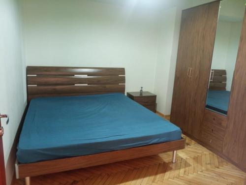 a bedroom with a bed and two wooden cabinets at City Center Cozy Apartment Tigran Mets in Yerevan