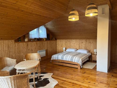 - une chambre avec un lit, une table et des chaises dans l'établissement Dom letniskowy nad jeziorem - Kaszuby, à Podjazdy