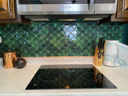 a kitchen with a sink and a green tiled wall at Ancla Suite 9 - Urban Hotel in Puerto Peñasco