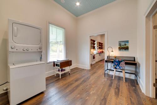 a living room with a flat screen tv and a desk at Restored Home Near Downtown Thomasville in Thomasville