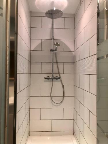 une salle de bain avec une douche avec pommeau de douche dans l'établissement Le Cerisier Saint-Barbant, à Saint-Barbant