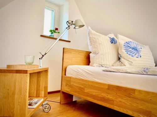 a bedroom with a bed with a lamp and a table at Apartment am Schlosshof in Besigheim