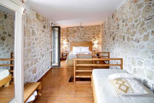 sypialnia z łóżkiem i kamienną ścianą w obiekcie Pool Villa Leonidas Crete w mieście Stíronas