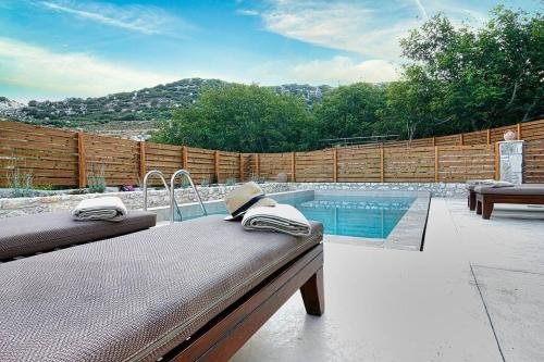 a backyard with a swimming pool and a wooden fence at Pool Villa Leonidas Crete in Stíronas