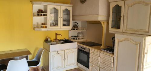 een keuken met witte kasten en een wastafel bij POOL HOUSE AVEC PISCINE ET SPA - RESIDENCE PRIVEE in Milhaud
