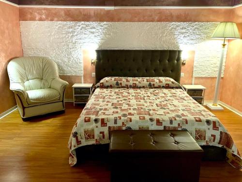 1 dormitorio con 1 cama y 1 silla en Castelpetroso Bed&Breakfast, en Castelpetroso