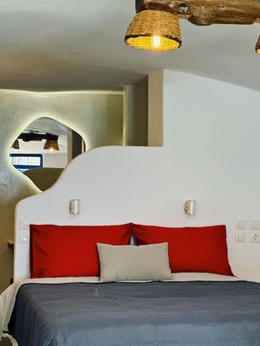 1 dormitorio con 1 cama con sábanas rojas y azules en Cave Beach House Milos, en Provatas