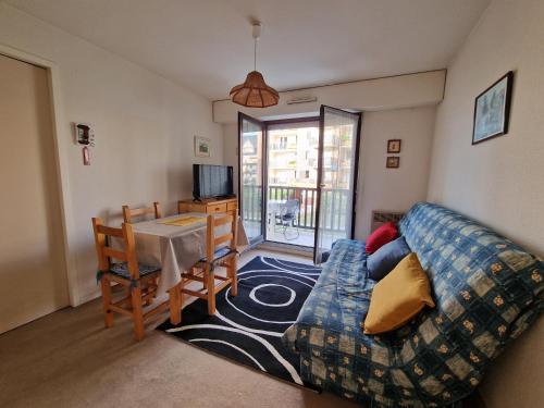 un salon avec un canapé et une table dans l'établissement Les pieds dans le sable, à Cabourg
