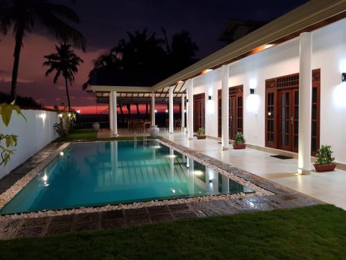 uma piscina no quintal de uma casa à noite em Tortuga Beach Hotel em Paiyagala South