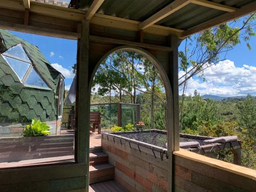 an arched doorway to a wooden deck with a pergola at PrivaDome in Rionegro