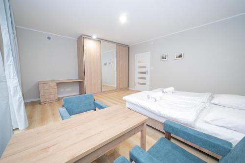 a bedroom with a bed and a table and chairs at VacationClub – Zdrojowa 7 Apartament 6 in Duszniki Zdrój