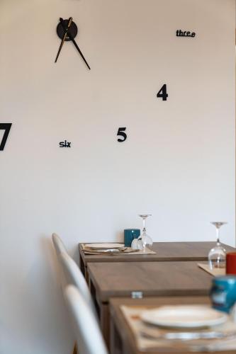 a clock on a wall above a table at B&B La Figuretta in Iesi