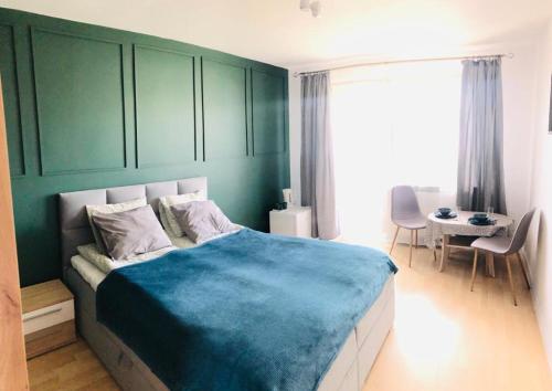 ブワディスワボボにあるBałtycki Zakątekのベッドルーム1室(大型ベッド1台、青い毛布付)