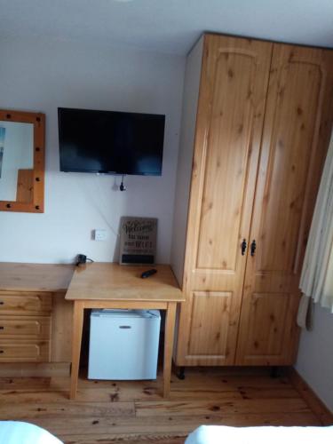 een kamer met een bureau en een tv aan de muur bij Parnell house in Ennis