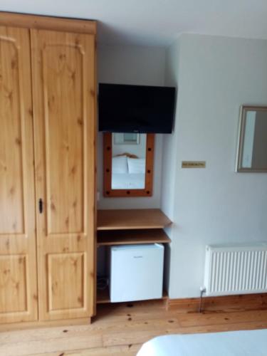 uma cozinha com um armário e uma televisão num quarto em Parnell house em Ennis