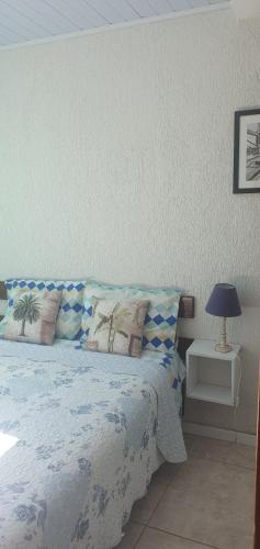 a bedroom with a bed and a lamp on a table at Bela vista in Mangaratiba