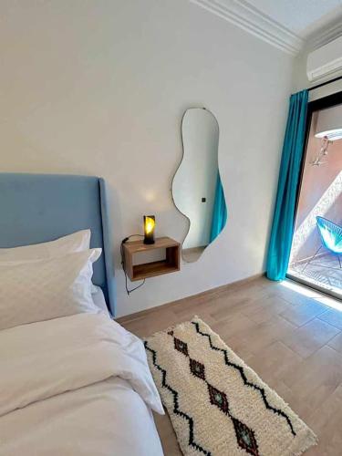 a bedroom with a bed with a lamp and a window at Appartement Annakhil in Rabat