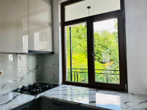 uma cozinha com uma janela com vista para uma varanda em House in Tsikhisdziri em Kobuleti