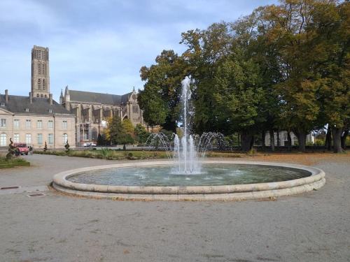 une fontaine dans un parc en face d'un bâtiment dans l'établissement Résidence de l'évèché 7, à Limoges