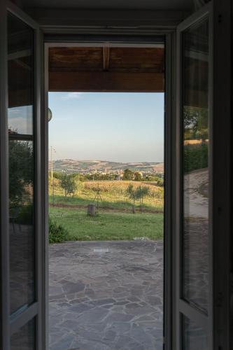 an open glass door with a view of a field at B&B La Figuretta in Iesi