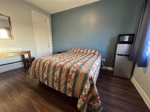 a bedroom with a bed with a colorful bedspread at Unity Hotel - No Parking & Rooms Are Upstairs in Long Beach