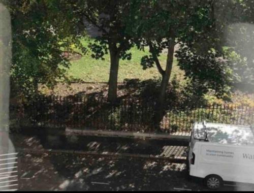 a white van parked next to a fence with trees at One Bedroom Flat in the heart of Islington in London