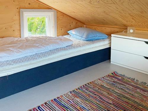 1 dormitorio con cama, ventana y alfombra en Holiday home HUNNEBOSTRAND XI en Hunnebostrand